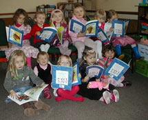 Members and friends of Oldbury on Severn Busy Bees playgroup in South Gloucestershire reading Amazing Grace.