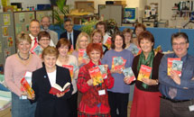 Staff at Devon Libraries headquarters with books and guides.