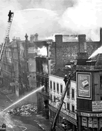 Fireman working from ladders following raid.